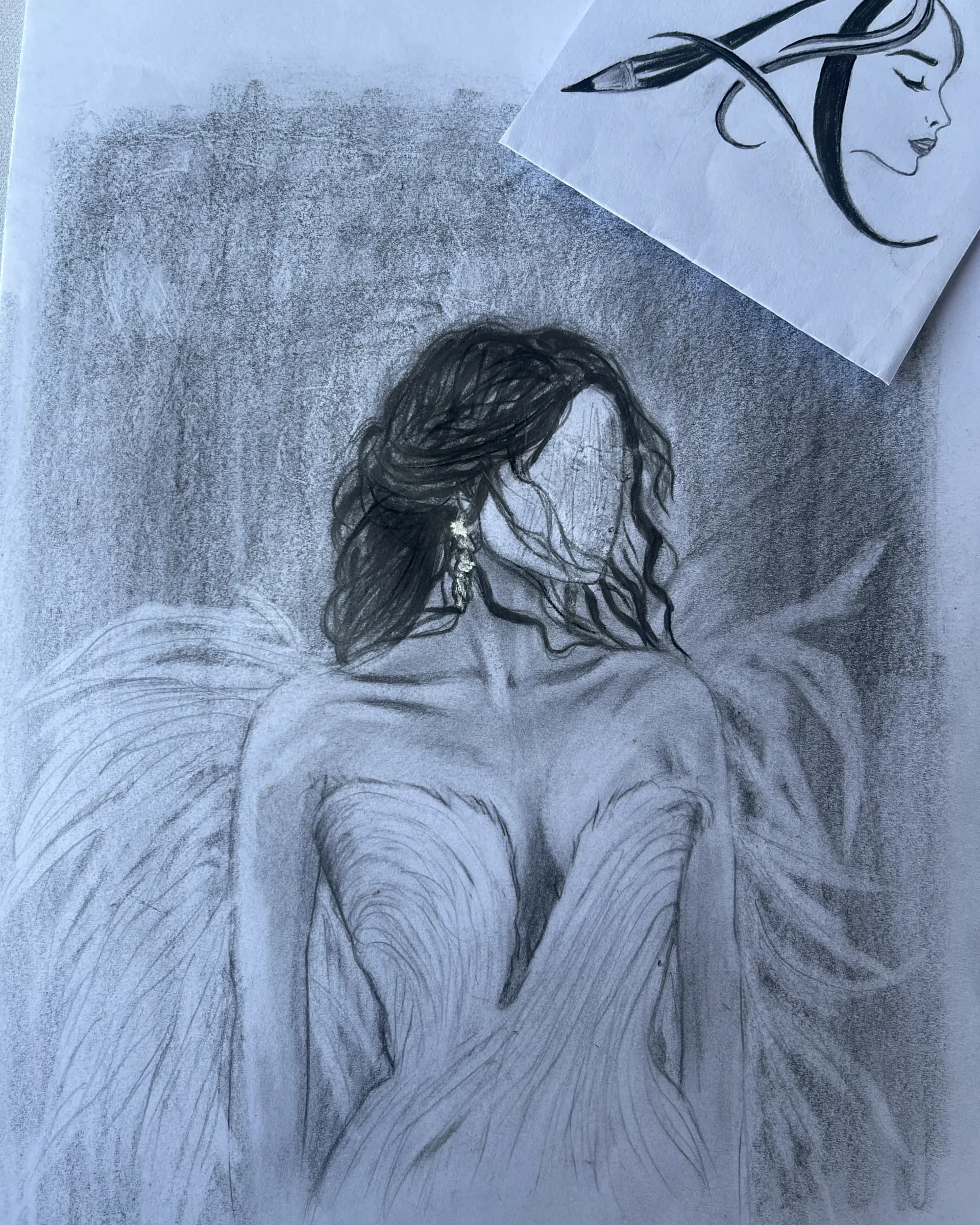 Hand-drawn graphite conceptual artwork featuring an inverted face with closed eyes, flowing hair, and dark organic forms rendered with soft pencil shading by Ammama Sketch.