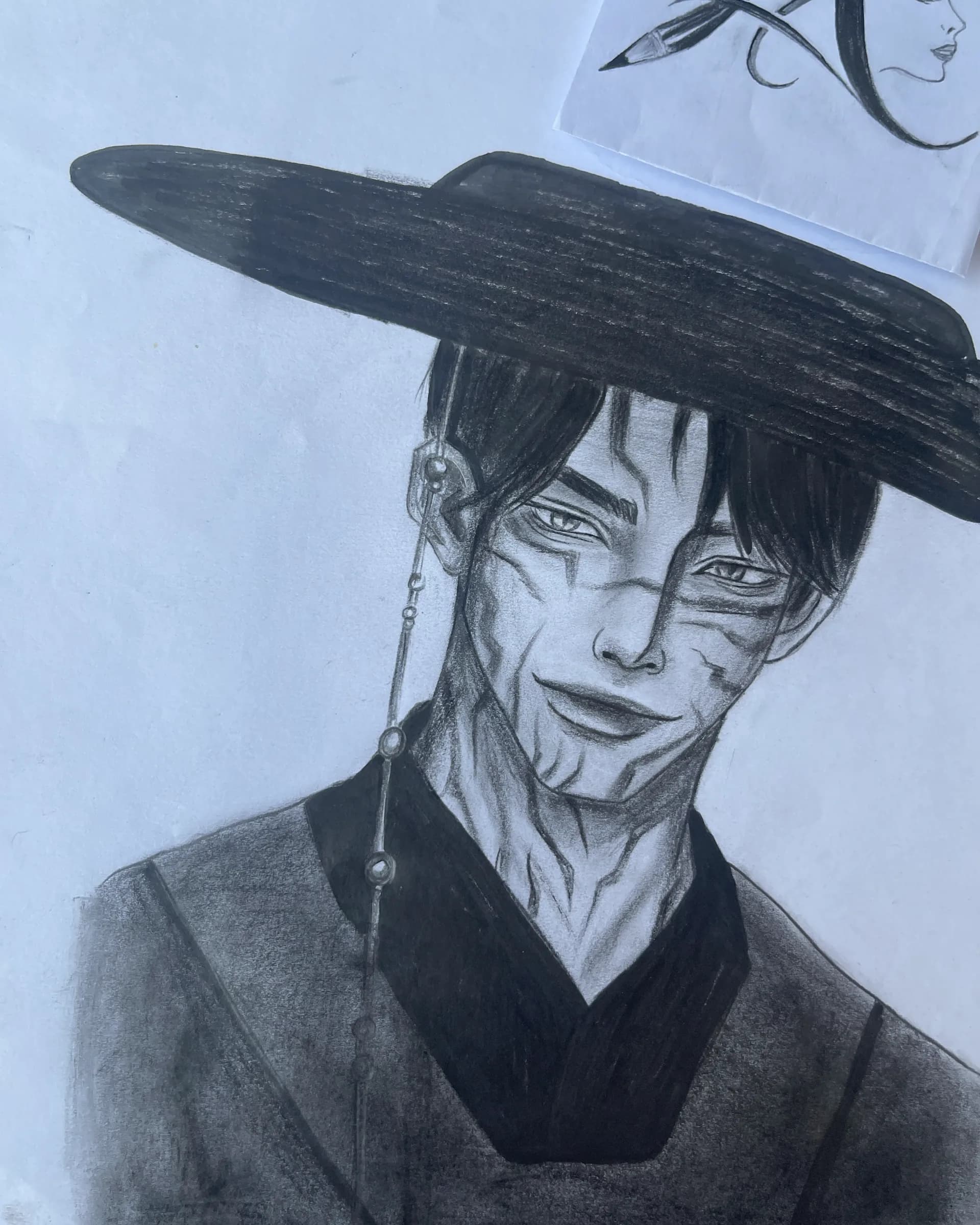 Hand-drawn graphite fantasy character portrait featuring a woman in a large dark hat with detailed facial shading, jewelry, and dramatic contrast by Ammama Sketch.